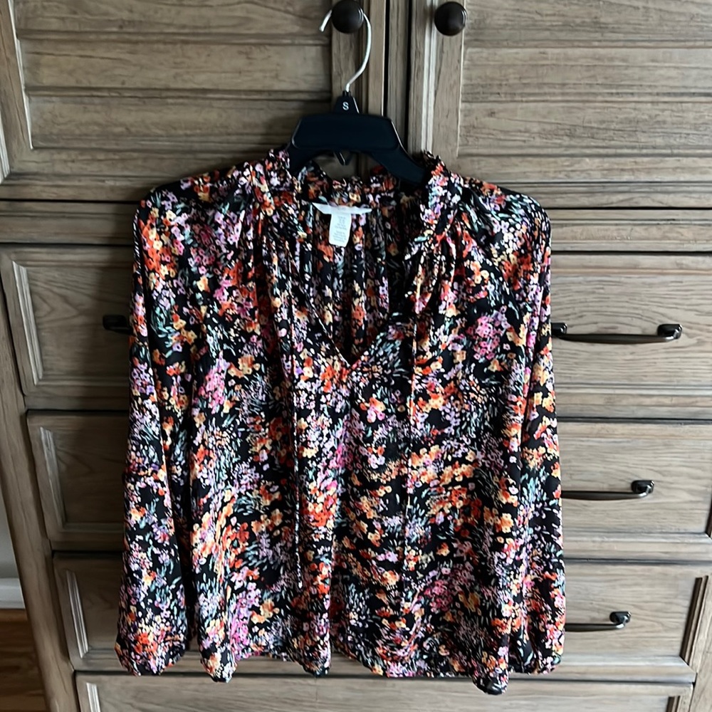 Floral blouse with ruffle tie collar.